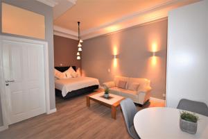 um quarto com uma cama, um sofá e uma mesa em Connie's Apartments em Heidelberg
