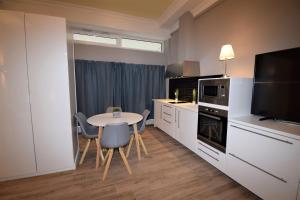 a kitchen with a table and chairs and a television at Connie's Apartments in Heidelberg +15 photos