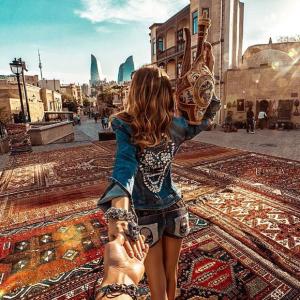 a person taking a picture of a woman standing on a rug at Liman Hotel Baku in Baku