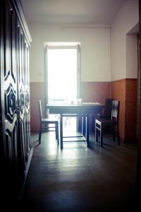 a room with a table, chairs and a window at Hostel Portalegre in Portalegre