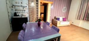 a dining room with a purple table and chairs at Castello Apartment Deluxe in Sciacca