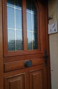 una puerta de madera con una ventana en ella en L'écoutille en Dieppe