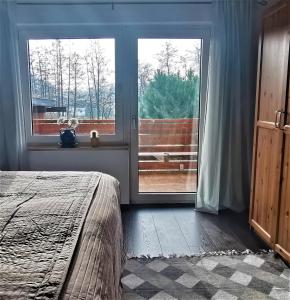 a bedroom with a bed and a large window at Aurach - SmartApart in Falkendorf