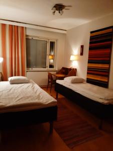 ein Hotelzimmer mit 2 Betten und einem Fenster in der Unterkunft Apartment Vuorikatu 35 Mummola in Kuopio