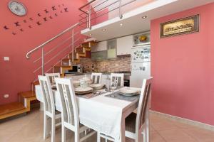 a dining room with a white table and chairs at Apartman Monika in Omiš