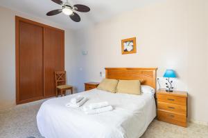 a bedroom with a bed with two towels on it at Apartamentos Guerrero in Torre del Mar