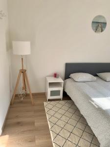 ein Schlafzimmer mit einem Bett und einem Nachttisch mit einer Lampe in der Unterkunft Charming Europarlament Resedence in Brüssel