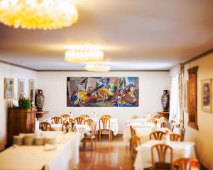 un comedor con mesas y sillas y una pintura en la pared en Hotel Corona, en Cortina dʼAmpezzo