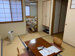 a room with a table and a room with a bed at Annex Turtle Hotori-An in Nikko
