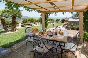 a table and chairs under a pergola with food on it at Villa Annetta in Poggi