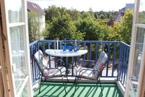 een veranda met een tafel en stoelen op een balkon bij Ferienwohnung Seeanemone I in Graal-Müritz