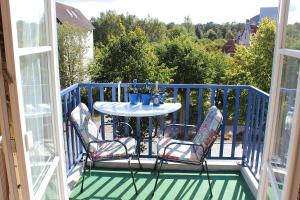 a porch with a table and chairs on a balcony at Ferienwohnung Seeanemone I in Graal-Müritz