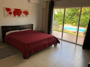 a bedroom with a bed and a view of a pool at Villa Les Trois Moulins in Saint-François +29 photos