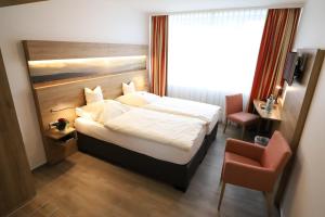Postel nebo postele na pokoji v ubytování Hotel Wiehen-Therme