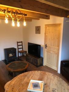 a living room with a table and a tv and a wood stove at La bergerie in Saint-Apollinaire-de-Rias