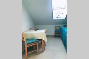 a dining room with a table and two chairs at Apartman Santorini in Novi Sad