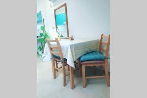 a dining room table with two chairs and a mirror at Apartman Santorini in Novi Sad