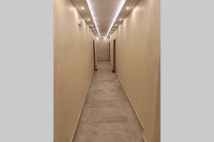 a hallway with white walls and a long corridor at Apartman Santorini in Novi Sad
