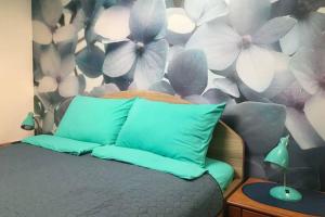 a bedroom with a bed with a flower wall at Apartman Santorini in Novi Sad
