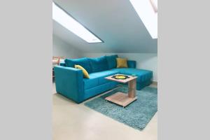 a blue couch in a living room with a table at Apartman Santorini in Novi Sad
