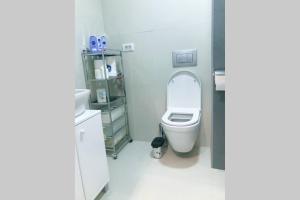 a bathroom with a white toilet in a room at Apartman Santorini in Novi Sad +37 photos