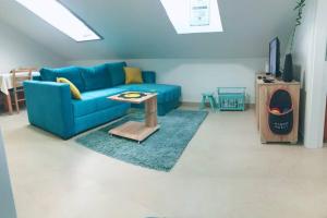 a living room with a blue couch and a table at Apartman Santorini in Novi Sad