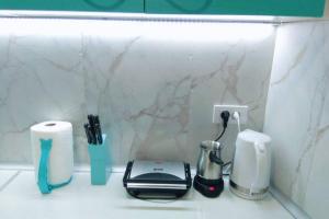 a kitchen counter with a toaster and other kitchen appliances at Apartman Santorini in Novi Sad