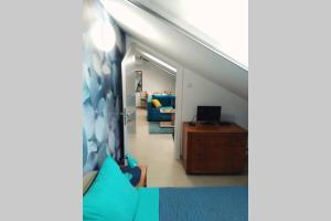 a living room with a couch and a clock on the wall at Apartman Santorini in Novi Sad