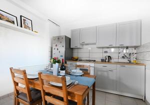 a kitchen with a table and chairs and white cabinets at Zagreb Apartmani Santana in Zagreb +20 photos