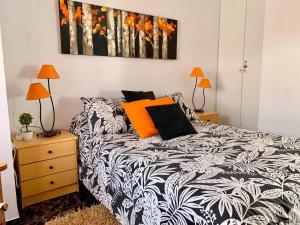 a bedroom with a black and white bed and two lamps at Apartamento diáfano y luminoso en Onil in Onil