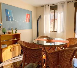 ein Esszimmer mit einem Tisch und Korbstühlen in der Unterkunft Apartamento diáfano y luminoso en Onil in Onil