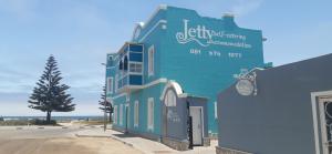 un bâtiment bleu avec un panneau sur son côté dans l'établissement Jetty Self-Catering, à Swakopmund