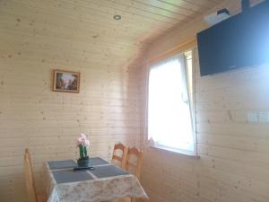 ein Esszimmer mit einem Tisch und einem Fenster in der Unterkunft Domki pod Żukowcem in Solina