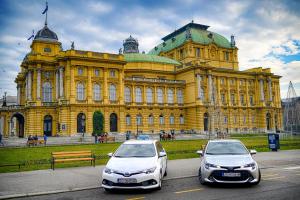 two cars parked in front of a yellow building at Zagreb Apartmani Santana in Zagreb