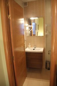 a bathroom with a sink and a mirror at Hostal Maury in El Barraco