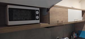 um micro-ondas numa prateleira de madeira numa cozinha em Lukas Guest Rooms na Cracóvia