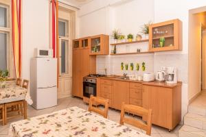 - une cuisine avec des placards en bois et un réfrigérateur blanc dans l'établissement Danubius Grand Astoria Budapest, à Budapest