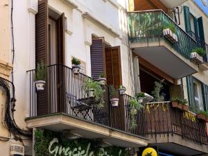 een gebouw met een balkon met potplanten erop bij Duplex ARTE Apartamento Sitges in Sitges