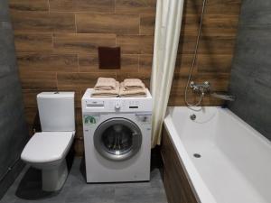 a bathroom with a washing machine and a toilet and a tub at Апарт-сервис s1 in Uzhhorod +4 photos