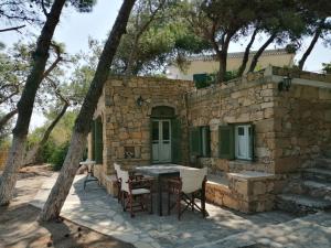 a stone house with a table and chairs at Petrino 2 - Traditional Lerian House in Lakkíon