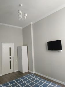 a living room with a tv and a white wall at Apartmen28juni in Chernivtsi