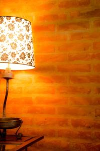 una lámpara en una mesa junto a una pared de ladrillo en El Granero en Sierra de los Padres