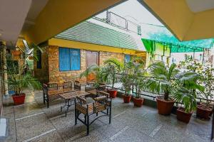 un patio con bancos y macetas en un edificio en The Trekkers Hostel - Dehradun, en Dehradun