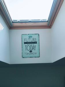 a sign on the ceiling of a room with a window at Apartman Santorini in Novi Sad