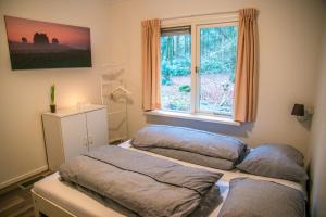 two beds in a room with a window at Vakantiehuis 't Musje in Epe