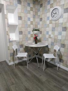 a table and chairs with a clock on a wall at Apartmen28juni in Chernivtsi