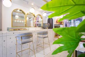 Isara Boutique Hotel and Cafe في فوكيت تاون: مخزن مع اثنين من المقاعد بار ومكتب مع المرايا