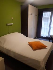 ブランケンベルヘにあるApartment Havenzichtの大きな白いベッド(オレンジ色の枕付)
