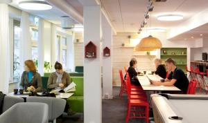 a group of people sitting at tables in a restaurant at Backpackers Göteborg in Gothenburg
