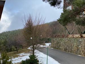 uma estrada com uma parede de pedra e uma ponte em Apartamento estacion de esqui la pinilla em La Pinilla